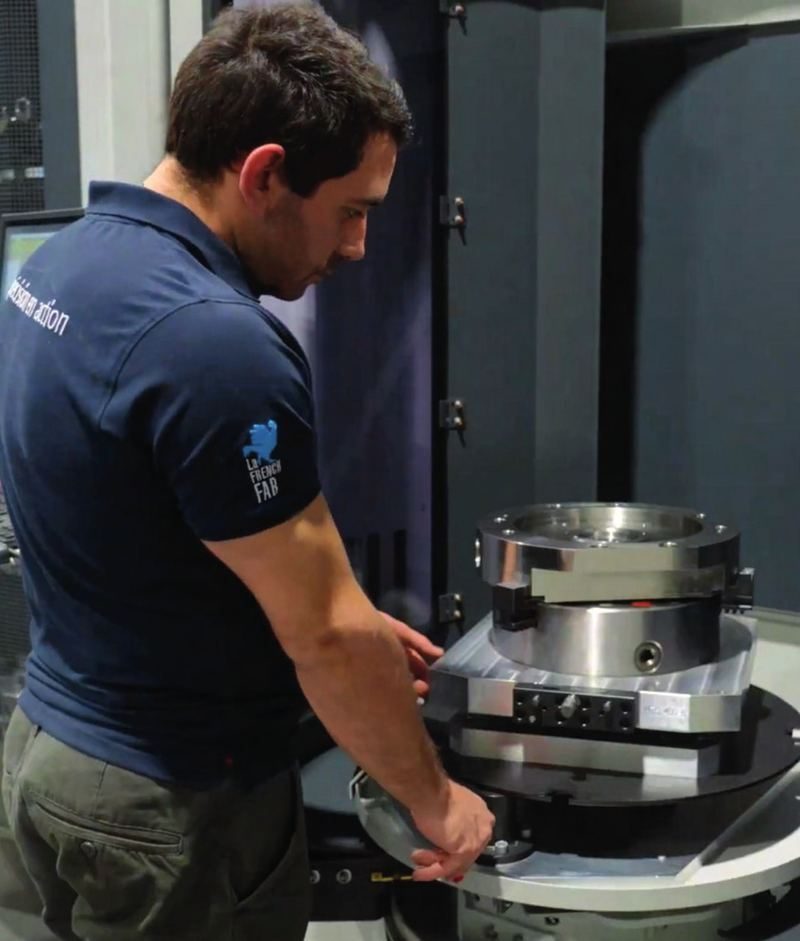 Technicien installant une pièce sur une machine, à son poste